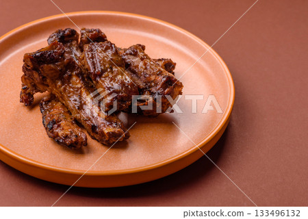 Grilled beef or pork ribs, meat cooked on a barbecue with salt and pepper. Grilled ribs Grilled beef or pork ribs, meat cooked on a barbecue with salt and pepper. Grilled ribs 133496132