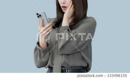 A woman/businesswoman is surprised at the screen of her smartphone 133496150
