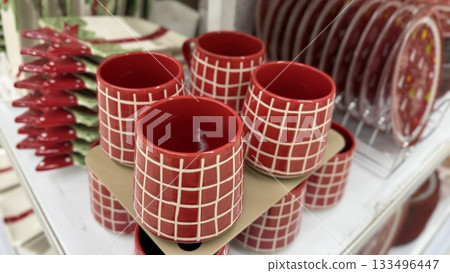 Christmas-themed red plaid mugs displayed on store shelf for festive home decor concept 133496447