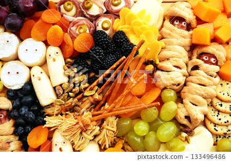 Healthy Halloween fun food mix: cheese ghosts and mummies, banana ghosts and grapes, blueberries and blackberries. Party spooky snacks for kids 133496486