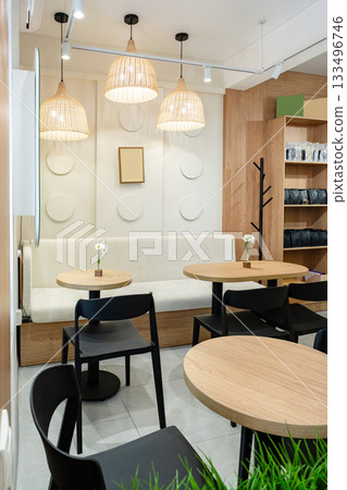 Cozy cafe interior with natural lighting and modern furniture in a stylish setting Cozy cafe interior with natural lighting and modern furniture in a stylish setting 133496746