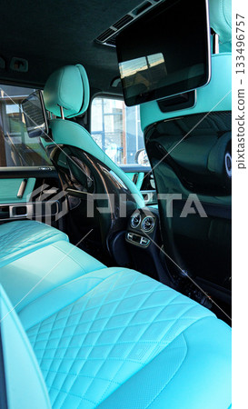 Luxury car interior with turquoise leather seats and modern technology visible 133496757