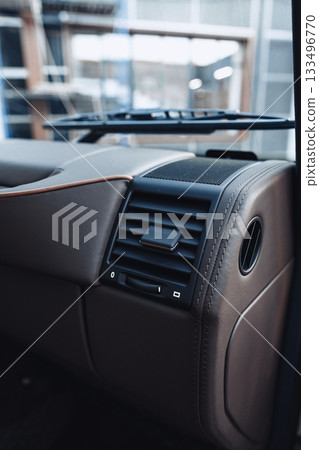 Interior details of a modern vehicle showcasing elegant design features and controls 133496770