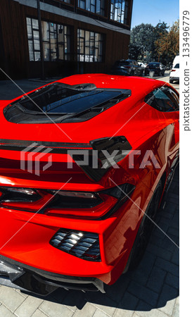 Red sports car parked on city street showcasing sleek design and modern features 133496779