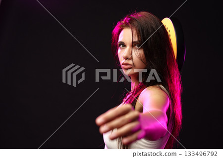 Woman reaching out with hand, showcasing confidence in a dramatic light setting Woman reaching out with hand, showcasing confidence in a dramatic light setting 133496792