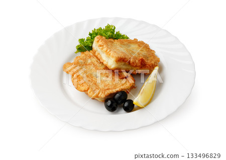 Delicious golden fried fish fillets served with fresh greens and lemon wedge 133496829