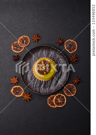 Pistachio cake or tart topped with green mousse with nuts and fruit filling. Pistachio pie 133496852