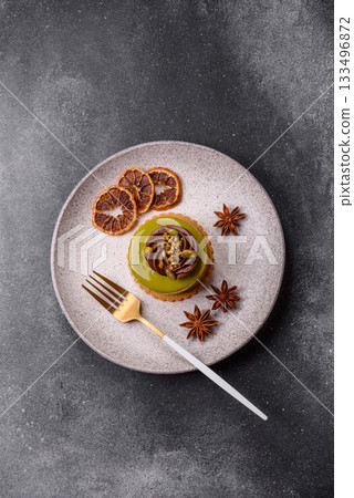 Pistachio cake or tart topped with green mousse with nuts and fruit filling. Pistachio pie 133496872