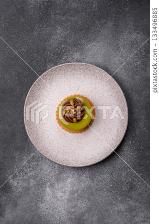 Pistachio cake or tart topped with green mousse with nuts and fruit filling. Pistachio pie Pistachio cake or tart topped with green mousse with nuts and fruit filling. Pistachio pie 133496885