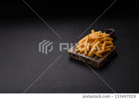 Crispy French fries with sauce, fast food, snack or chips. French fries, takeaway food 133497029