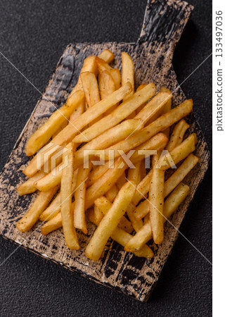 Crispy French fries with sauce, fast food, snack or chips. French fries, takeaway food 133497036