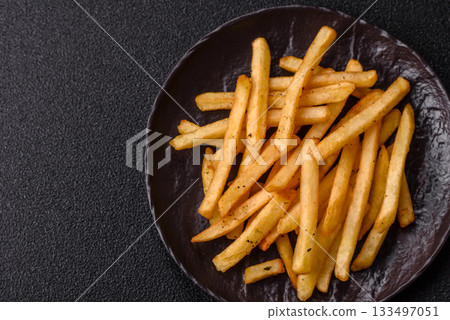 Crispy French fries with sauce, fast food, snack or chips. French fries, takeaway food Crispy French fries with sauce, fast food, snack or chips. French fries, takeaway food 133497051