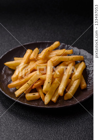 Crispy French fries with sauce, fast food, snack or chips. French fries, takeaway food 133497053
