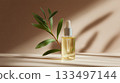 Golden serum bottle with green leaves in soft natural light 133497144