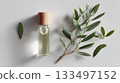 Essential oil bottle with natural leaves on a light surface in a calm setting 133497152