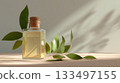 Glass bottle filled with essential oil near fresh green leaves on a soft surface 133497155