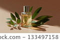 Glass bottle of perfume placed on a neutral background with leaves nearby 133497158