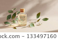 Essential oil bottle with green leaves in soft natural light setting 133497160
