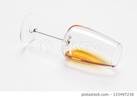 Wine glass with white wine lying on white background 133497238