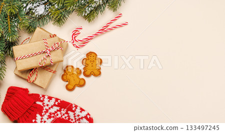 Christmas card with fir branches, gifts and cookies on beige surface 133497245