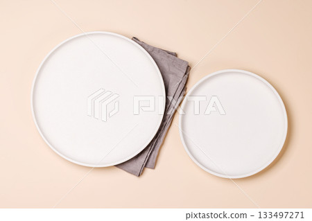 Empty plate on beige background, food mockup with natural light Empty plate on beige background, food mockup with natural light 133497271