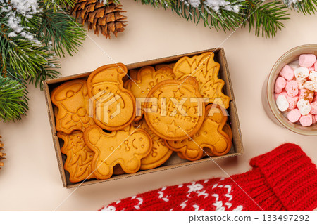 Gingerbread cookies, cup with marshmallows and snowy fir branches 133497292