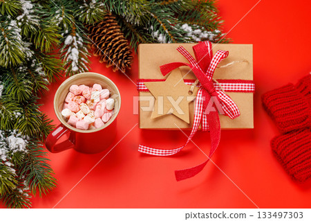 Gift box, cup with marshmallows, snowy fir branches 133497303