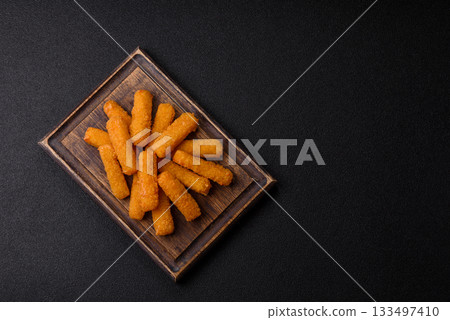 Mozzarella cheese sticks, crispy nutritious fast food. Cheese sticks as food background Mozzarella cheese sticks, crispy nutritious fast food. Cheese sticks as food background 133497410