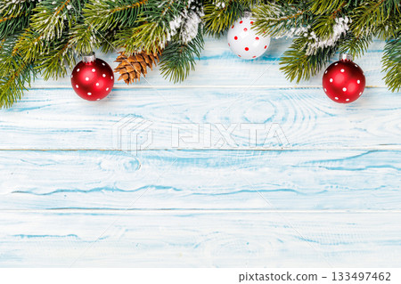Baubles and snowy fir branches on wooden background 133497462