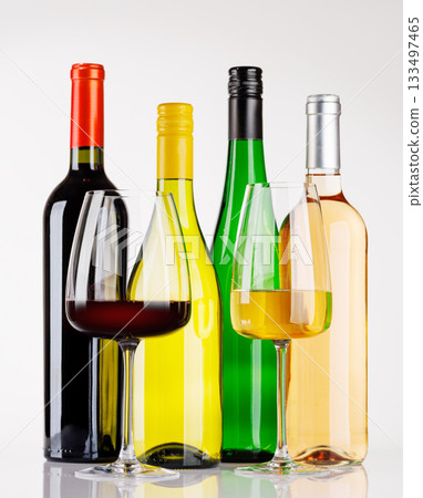 Different wine bottles and glasses on white background 133497465