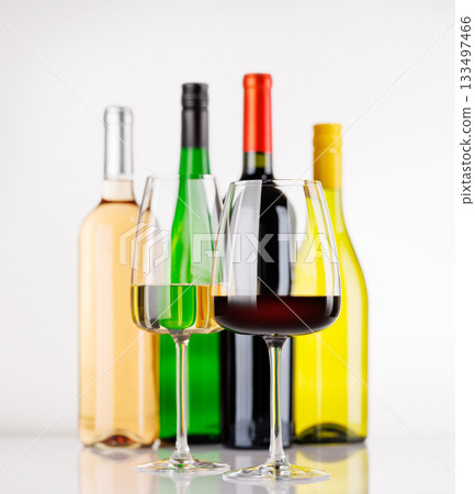 Different wine bottles and glasses on white background 133497466