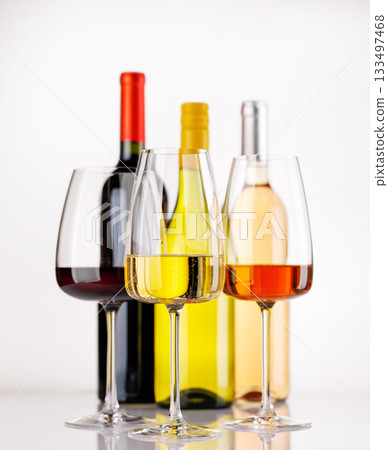 Different wine bottles and glasses on white background 133497468