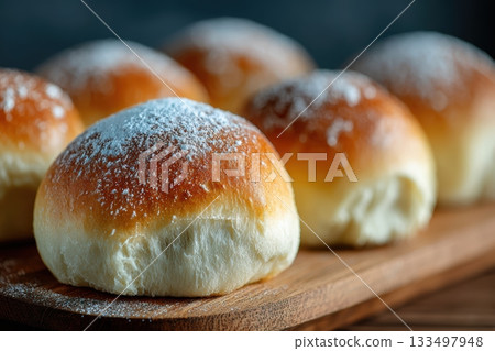 Soft and fluffy sweet buns on a wooden board display Soft and fluffy sweet buns on a wooden board display 133497948