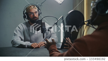 Two Men Wearing Headphones and Talking Into Professional Mics, Exchange Ideas Two Men Wearing Headphones and Talking Into Professional Mics, Exchange Ideas 133498192