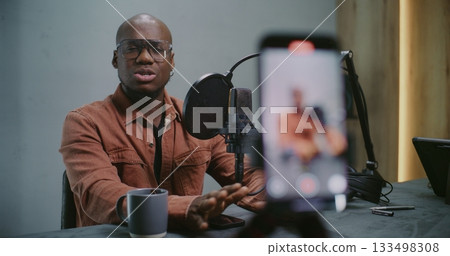 Process of Shooting Vertical Phone Footage in Which Man Speaking Confidently Into Professional Mic 133498308