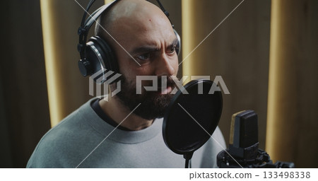 Professional Voice Actor Delivering Expressive Performance in Modern Recording Studio 133498338