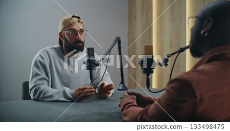 Men Having Friendly Podcast Discussion in Well Lit Studio 133498475