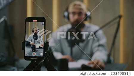 Vertical Phone View Frames Podcast Host Delivering Remarks With Clear Gestures Toward Microphone Vertical Phone View Frames Podcast Host Delivering Remarks With Clear Gestures Toward Microphone 133498514