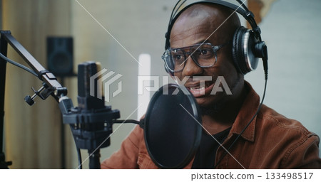 Confident Podcast Guest Wearing Glasses and Large Headphones Speaks Confident Podcast Guest Wearing Glasses and Large Headphones Speaks 133498517