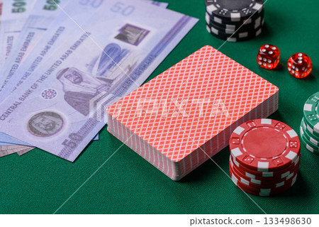 Casino game in the United Arab Emirates, dirham, chips, cards. Gambling in casinos in the Emirates Casino game in the United Arab Emirates, dirham, chips, cards. Gambling in casinos in the Emirates 133498630