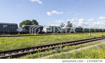 Railroad cars for transporting crushed stone and bulk building materials. Freight cars on the tracks on a sunny day 133498734