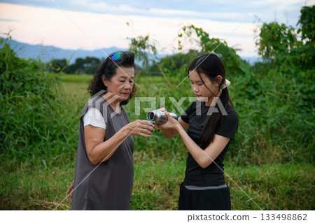 Grandma and granddaughter walk together in the park 133498862