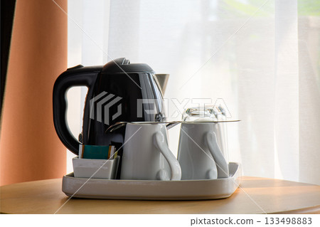 Kettle and tea cup in the living room Kettle and tea cup in the living room 133498883