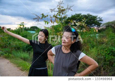 Grandma and granddaughter walk together in the park 133498968