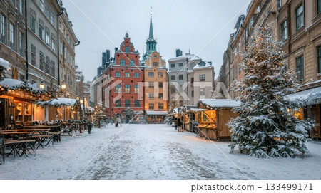 A snowy European street glows with Christmas market lights and decorated trees A snowy European street glows with Christmas market lights and decorated trees 133499171