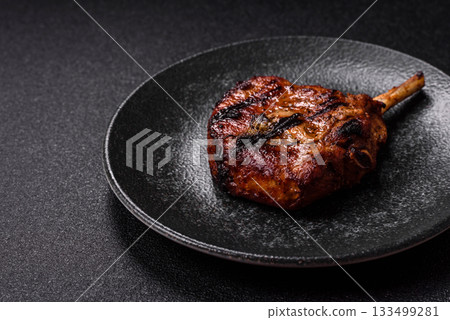 Steak, beef or pork on the bone, meat cooked on the grill with rosemary. Steak on the bone Steak, beef or pork on the bone, meat cooked on the grill with rosemary. Steak on the bone 133499281