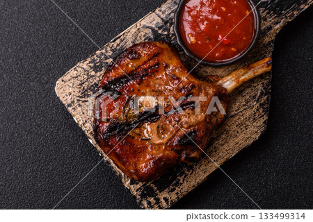 Steak, beef or pork on the bone, meat cooked on the grill with rosemary. Steak on the bone Steak, beef or pork on the bone, meat cooked on the grill with rosemary. Steak on the bone 133499314