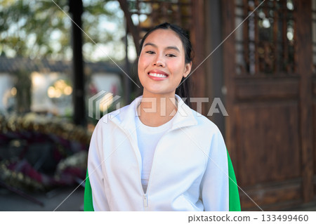 Young Asian Woman in Sporty Casual Outfit Outdoors Young Asian Woman in Sporty Casual Outfit Outdoors 133499460