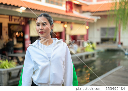 Young Asian Woman in Sporty Casual Outfit Outdoors in Zen Garden Young Asian Woman in Sporty Casual Outfit Outdoors in Zen Garden 133499484