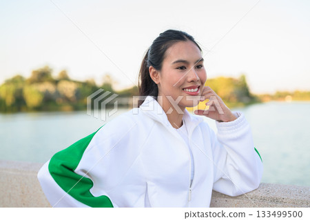 Young Asian Woman in Sporty Casual Outfit Outdoors in Lake Garden Young Asian Woman in Sporty Casual Outfit Outdoors in Lake Garden 133499500